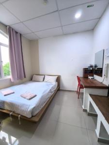 a bedroom with a bed and a desk in it at Tang Hotel in Alor Setar