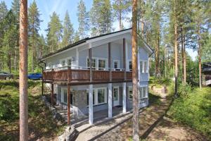 a house with a wrap around porch in the woods at Pielusrinne in Hattusaari