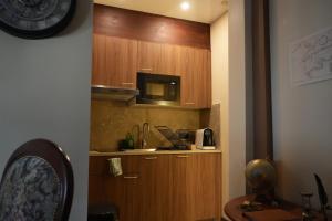 a kitchen with wooden cabinets and a microwave and a counter at Cabin 13 Immersive Suite with Balneotherapy in Boulogne-sur-Mer