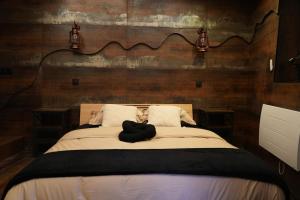 a bed with a black hat on top of it at Cabin 13 Immersive Suite with Balneotherapy in Boulogne-sur-Mer +17 photos