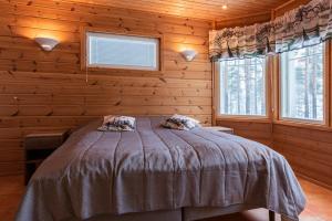 a bedroom with a bed in a log cabin at Pielusrinne in Hattusaari