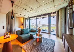 a living room with a couch and a table at The Zipper Hotel und Apartments in Düsseldorf +110 photos