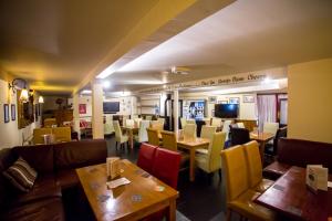 a restaurant with tables and chairs and a dining room at The Horse and Jockey in Stapleford