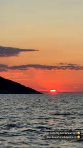 a sunset over the ocean with the sun setting at Jarfjord Nature Escape in Herjenes +5 photos