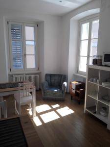 a living room with a chair and a table at Palazzo Brigido Apartment in Trieste