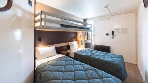 a hotel room with two beds and a bunk bed at Premiere Classe Limoges Nord in Limoges