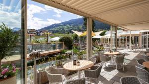 a patio with tables and chairs on a balcony at Hotel Magdalena im Zillertal - Urlaub mit Hund in Ried im Zillertal