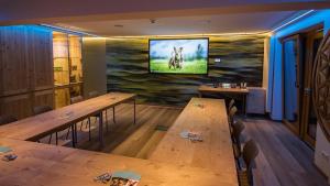 a room with two tables and a tv on a wall at Hotel Magdalena im Zillertal - Urlaub mit Hund in Ried im Zillertal