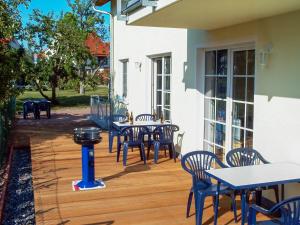 an outdoor patio with tables and chairs and a grill at Villa Lisa in Glowe