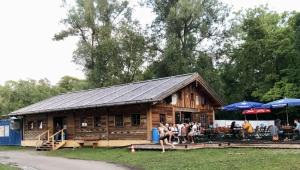 a log cabin with people sitting outside of it at Munich Oktoberfest Central Camping Village in Munich