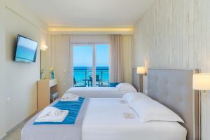 a hotel room with two beds with a view of the ocean at Iliorama Luxury Apartments in Skala Potamias