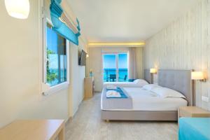 two beds in a room with a view of the ocean at Iliorama Luxury Apartments in Skala Potamias