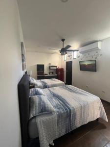 a bedroom with a bed with a blanket on it at Cozy room La Flor in Jacó