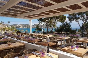a restaurant with tables and chairs and a view of the ocean at MARETA - Managed by Almarina in Teulada
