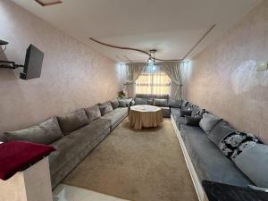 a living room with a large couch and a table at appartement luxe in Berkane