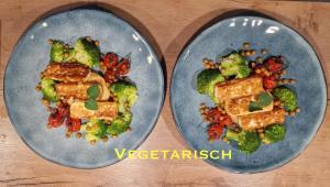 zwei Teller mit Brokkoli und Tofu in der Unterkunft Haus Chresten in Büllingen