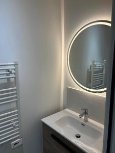 a bathroom with a sink and a mirror at Les Granges Dorées in Châtillon +1 photo