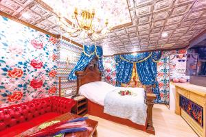 a bedroom with a bed and a red couch at Hotel Shiro No Kyuden in Ibaraki