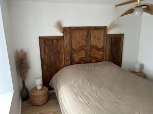 a bed with a wooden headboard in a bedroom at Les Granges Dorées in Châtillon