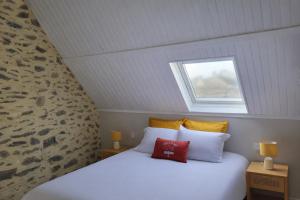 a bedroom with a white bed with a window at Les 3 Nuances in Saint-Suliac