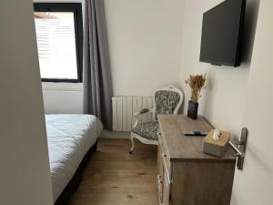 a bedroom with a bed and a desk and a chair at Les Granges Dorées in Châtillon