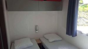 a small room with two beds and a window at ZEcamping 4 étoiles animaux acceptés animations piscine chauffée in Rosans +107 photos