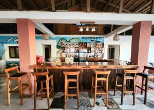 a bar in a restaurant with wooden stools at Coconut Resort in Tuléar