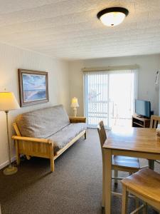 a bedroom with a bed and a table and a dining room at Snug Harbor Marina and Resort in Chincoteague