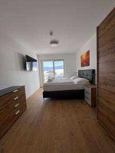 a large bedroom with a bed and a large window at Sun Terrace Apartment 04 I Gerlitzen-Ossiachersee I Alpe Maritima in Annenheim