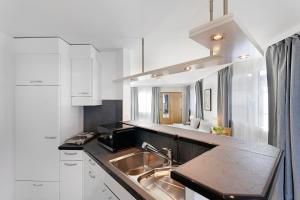 a kitchen with a sink and white cabinets at Hotel Schiff in Horn