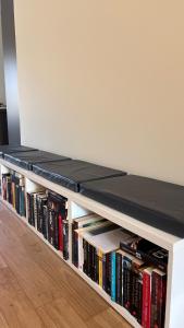 a white book shelf filled with books at Nette maisonnette in groene rustige wijk in Rijswijk