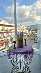 a purple table with flowers on top of a window at Mary's Apartment - Close to port, beaches in Kos