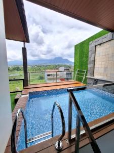 a swimming pool on a balcony with a view of the mountains at Athara Residence in Tlekung