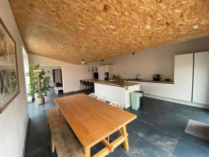 a kitchen with a wooden table in a room at Spacious house specially for workers and expats in Maldegem