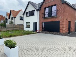 a brick house with a garage and a driveway at Spacious house specially for workers and expats in Maldegem