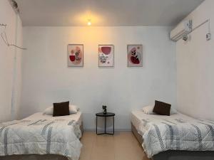 two beds in a room with white walls at HAPDESKO HOMESTAY in Batam Center +63 photos