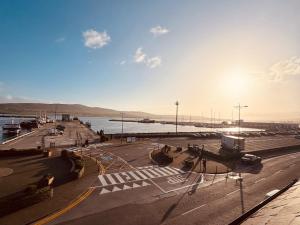 a view of a street with a river and the sun at Pier House Luxury Apartment in Dingle