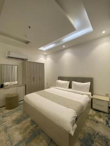 a bedroom with a large white bed in a room at كيان الين in Muhayil