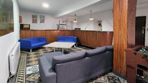 a waiting room with a couch and two blue chairs at Casa rural L´Amparo -3 espigas- Categoría superior-15 personas in Navarrete del Río