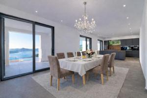 a dining room with a table with chairs and a chandelier at Villa Miramare in Blizikuće