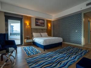 a bedroom with a bed and a blue patterned wall at Elite World Comfy Diyarbakır in Diyarbakır