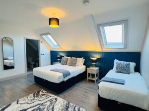 a bedroom with two beds and a mirror at Pier House Luxury Apartment in Dingle