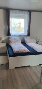 a bedroom with two beds and a window at Ferienwohnung Christel und Andreas in Sulzfeld