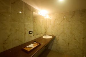 a bathroom with a sink and a mirror at Hotel Hemaadri Grand in Hyderabad +73 photos