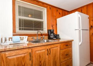 a kitchen with a sink and a white refrigerator at Snug Harbor Marina and Resort in Chincoteague +39 photos