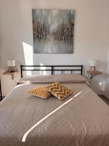 a bed with two pillows and a painting on the wall at Dimore Fronte Mare affittacamere in Casalbordino