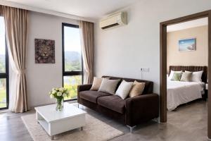 a living room with a couch and a bed at Aleksandra Royal Lee in Ban Bo Han