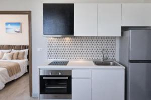 a kitchen with a sink and a bed in a room at Aleksandra Royal Lee in Ban Bo Han