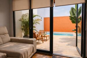 a living room with a couch and a swimming pool at Apartamento Maya Merida in Mérida