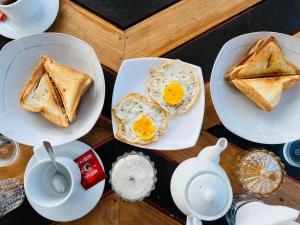 a table with two plates of eggs and toast at Flora Lake View Resort Wilpattu in Wilpattu +74 photos